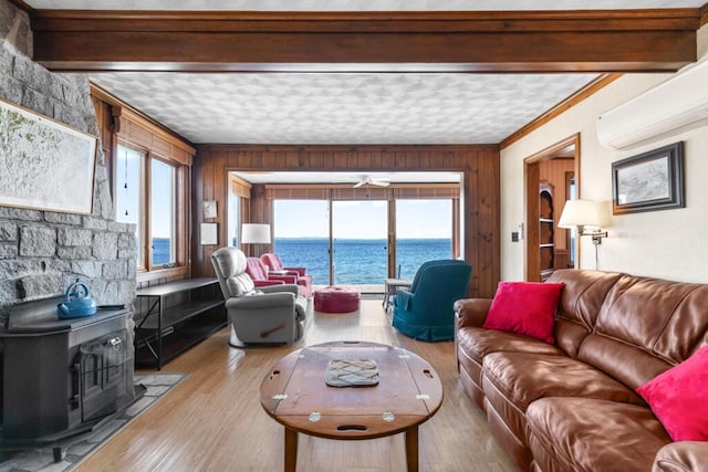73 Wards Cove Rd, Standish, ME 04084 - living room featuring a wood stove, a water view, ceiling fan, healthy amount of natural light, and beamed ceiling