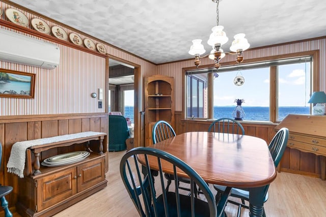 73 Wards Cove Rd, Standish, ME 04084 - dining room featuring a chandelier, light wood finished floors, a wall mounted air conditioner, wood walls, and a water view