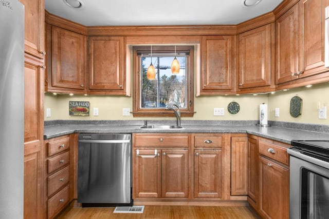 73 Wards Cove Rd, Standish, ME 04084 - kitchen with appliances with stainless steel finishes, a sink, dark countertops, and brown cabinetry