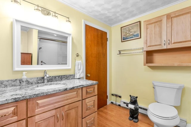 73 Wards Cove Rd, Standish, ME 04084 - bathroom with wood finished floors, vanity, toilet, a baseboard heating unit, and crown molding