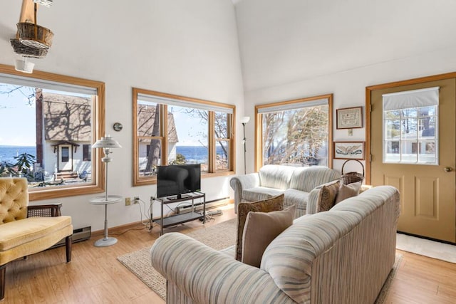 73 Wards Cove Rd, Standish, ME 04084 - living area with high vaulted ceiling, light wood finished floors, baseboards, and a baseboard heating unit