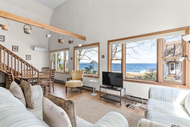73 Wards Cove Rd, Standish, ME 04084 - living area featuring high vaulted ceiling, wood finished floors, baseboard heating, stairs, and a wall mounted air conditioner