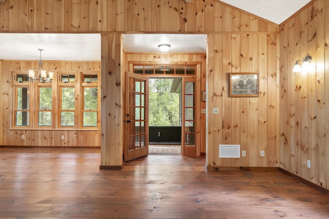 389 Castle Island Rd, Belgrade, ME 04917 - foyer with wooden walls, a chandelier, hardwood / wood-style floors, baseboards, and lofted ceiling