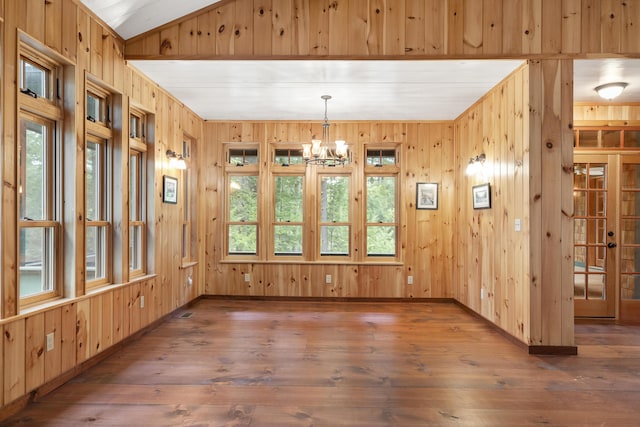 389 Castle Island Rd, Belgrade, ME 04917 - unfurnished dining area with wood walls, baseboards, hardwood / wood-style flooring, a chandelier, and vaulted ceiling