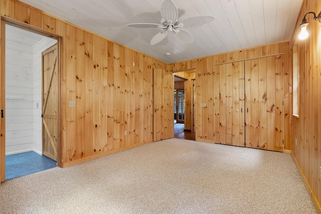 389 Castle Island Rd, Belgrade, ME 04917 - empty room featuring wooden walls, a ceiling fan, baseboards, and carpet