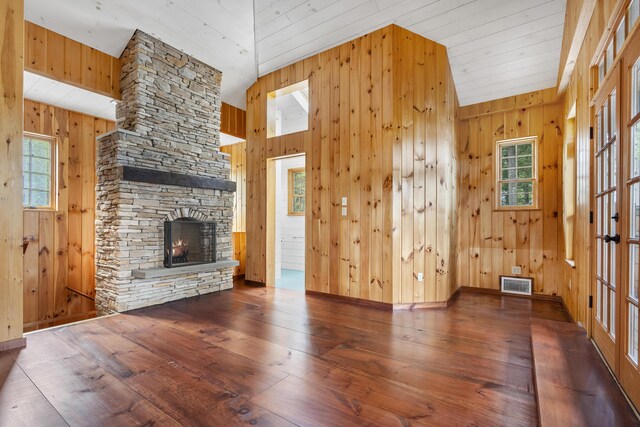 389 Castle Island Rd, Belgrade, ME 04917 - unfurnished living room featuring hardwood / wood-style flooring, a fireplace, and wooden walls