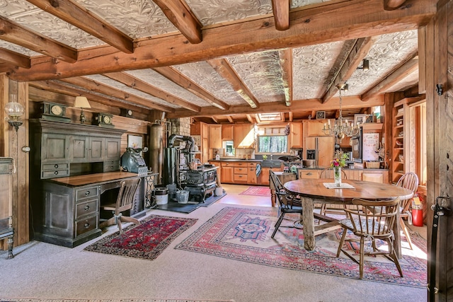 890 Salem Rd, Freeman Twp, ME 04983 - dining space with a wood stove, light colored carpet, a chandelier, wood walls, and beamed ceiling