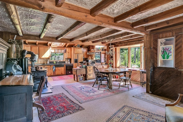 890 Salem Rd, Freeman Twp, ME 04983 - dining room with a wood stove, wood walls, and light colored carpet