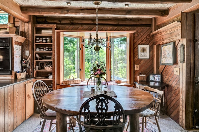 890 Salem Rd, Freeman Twp, ME 04983 - dining space with plenty of natural light, a chandelier, light carpet, wooden walls, and beamed ceiling