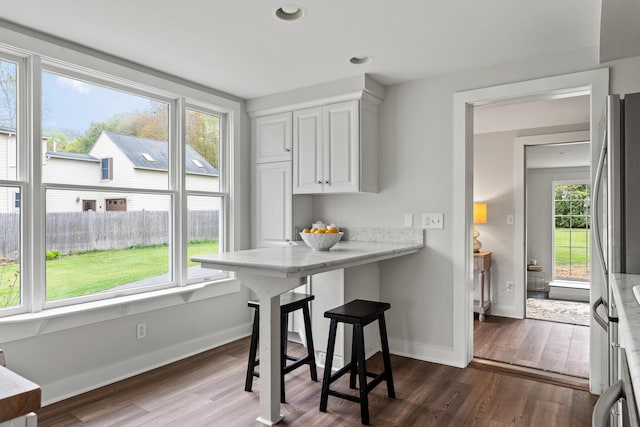 288 Foreside Rd, Falmouth, ME 04105 - kitchen featuring dark wood-style flooring, white cabinets, baseboards, a breakfast bar, and recessed lighting
