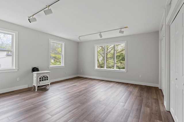 288 Foreside Rd, Falmouth, ME 04105 - empty room with track lighting, wood finished floors, a wood stove, and baseboards
