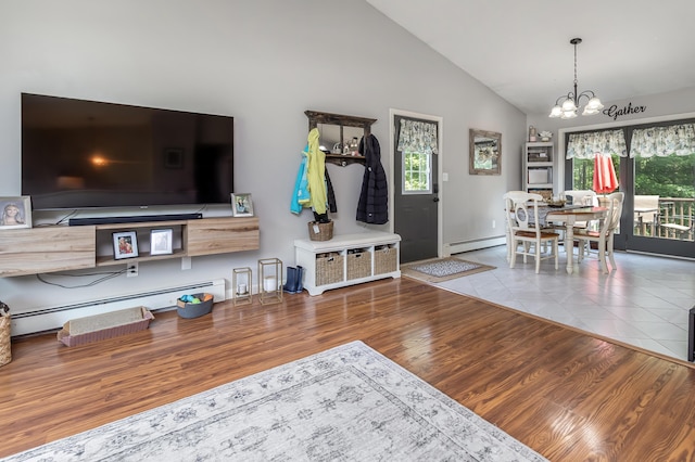 320 Grove St, Lewiston, ME 04240 - living area featuring a chandelier, a baseboard radiator, wood finished floors, and high vaulted ceiling