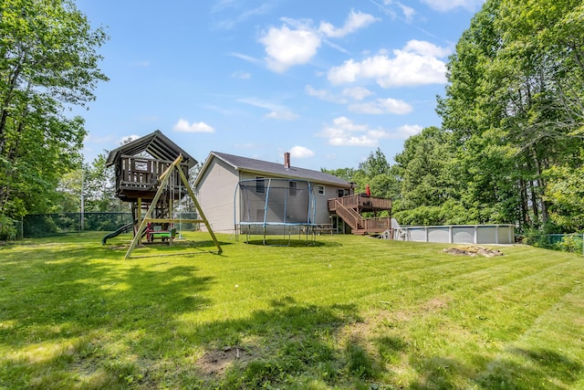 320 Grove St, Lewiston, ME 04240 - view of yard featuring stairway, a trampoline, a playground, a wooden deck, and an outdoor pool