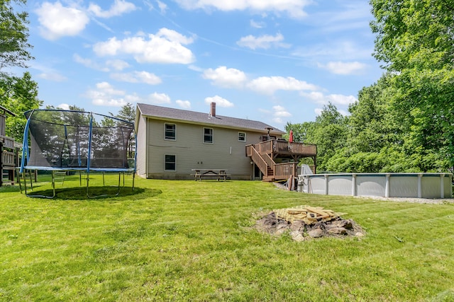 320 Grove St, Lewiston, ME 04240 - rear view of house with a trampoline, stairs, a deck, an outdoor fire pit, and an outdoor pool