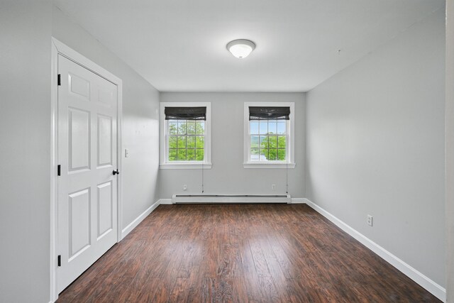 94 Staples Hill Rd, Canton, ME 04221 - unfurnished bedroom with a baseboard heating unit, dark wood-type flooring, and baseboards
