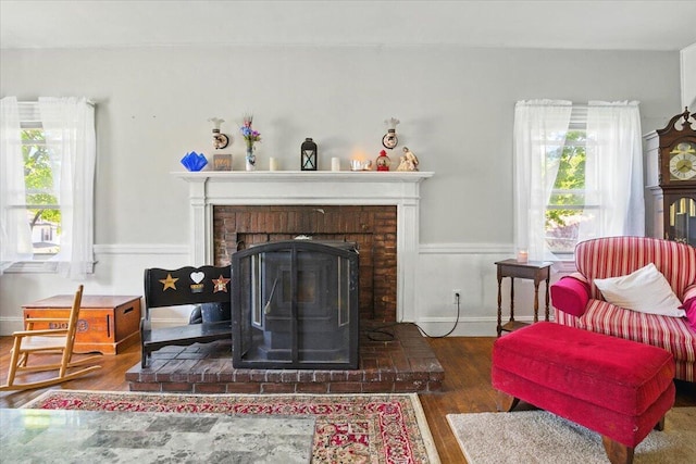 139 S Ave, Lewiston, ME 04240 - living area featuring wood finished floors, a brick fireplace, and plenty of natural light