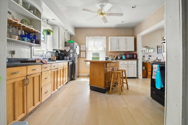 139 S Ave, Lewiston, ME 04240 - kitchen with appliances with stainless steel finishes, a kitchen breakfast bar, light wood-style floors, and plenty of natural light