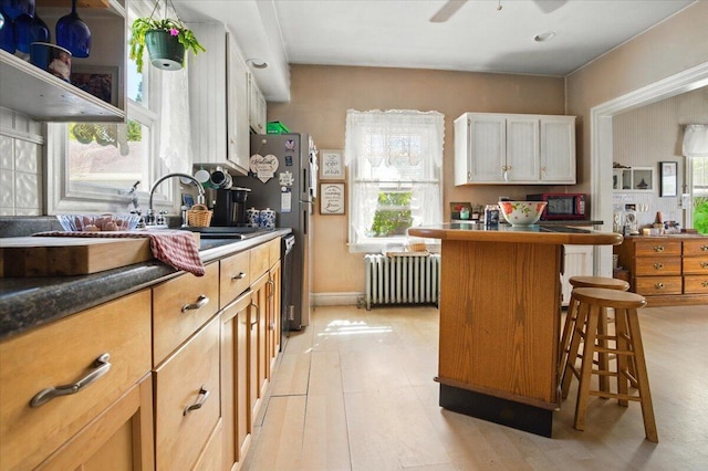 139 S Ave, Lewiston, ME 04240 - kitchen featuring radiator, a breakfast bar, white cabinetry, ceiling fan, and dishwasher