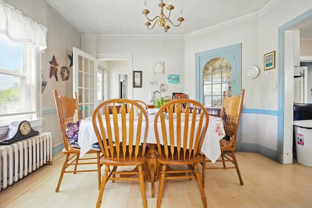 139 S Ave, Lewiston, ME 04240 - dining area with radiator, crown molding, light wood-type flooring, a chandelier, and wallpapered walls