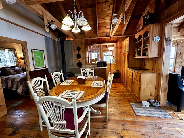 1080 Frenchtown Rd, Frenchtown Twp, ME 04441 - dining room featuring wooden walls, wood ceiling, hardwood / wood-style flooring, a chandelier, and a wood stove