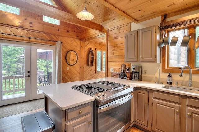 231 Kendall Farm Trl, Rangeley, ME 04970 - kitchen featuring stainless steel gas range, a sink, a peninsula, light countertops, and wood walls