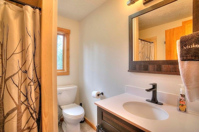 231 Kendall Farm Trl, Rangeley, ME 04970 - bathroom featuring a textured ceiling, toilet, vanity, and baseboards