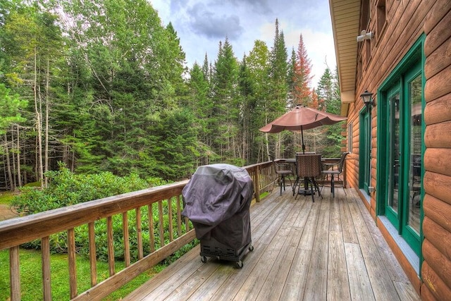 231 Kendall Farm Trl, Rangeley, ME 04970 - wooden terrace with outdoor dining space, grilling area, and a view of trees