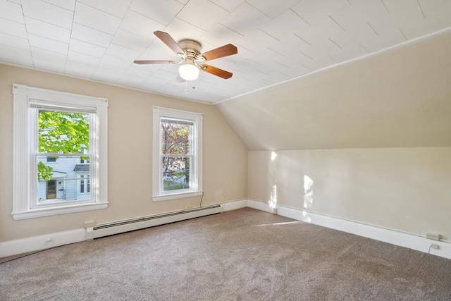 additional living space featuring a baseboard radiator, carpet flooring, a ceiling fan, baseboards, and vaulted ceiling