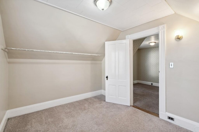 additional living space featuring carpet flooring, vaulted ceiling, and baseboards