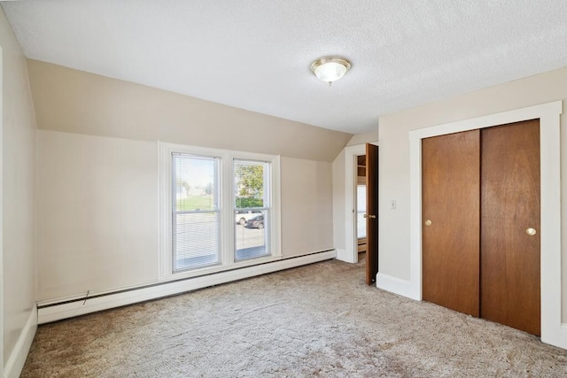 unfurnished bedroom featuring a baseboard radiator, carpet flooring, a closet, lofted ceiling, and a textured ceiling