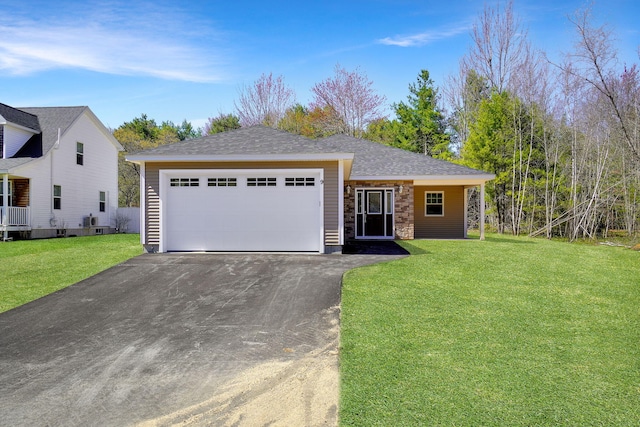 9 Country Dr, Old Orchard Beach, ME 04064 - view of front of property featuring driveway, a front yard, an attached garage, and stone siding
