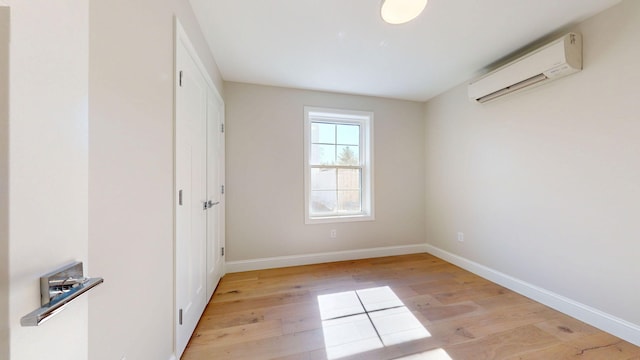 9 Country Dr, Old Orchard Beach, ME 04064 - unfurnished bedroom with an AC wall unit, light wood-style floors, and baseboards