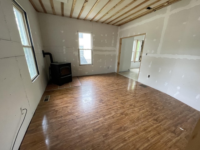 172 Highland Ave, Gardiner, ME 04345 - unfurnished living room with a wood stove and wood finished floors
