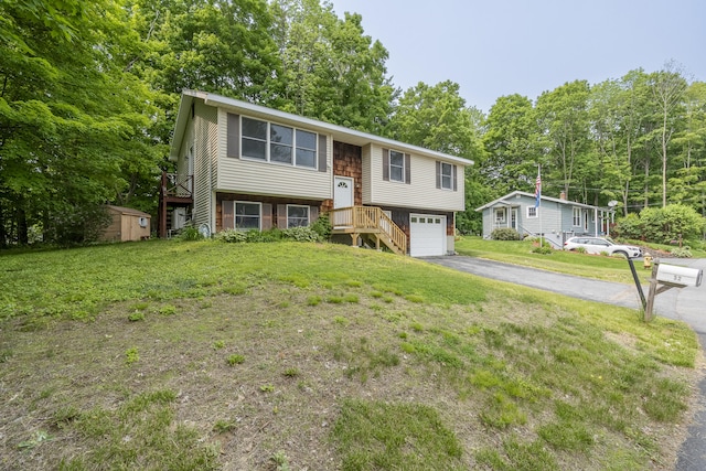 32 Thorne Ave, Lewiston, ME 04240 - raised ranch featuring driveway, a garage, a front yard, and view of scattered trees