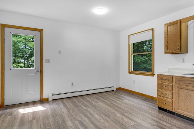 32 Thorne Ave, Lewiston, ME 04240 - unfurnished dining area with a baseboard radiator, light wood-type flooring, and baseboards