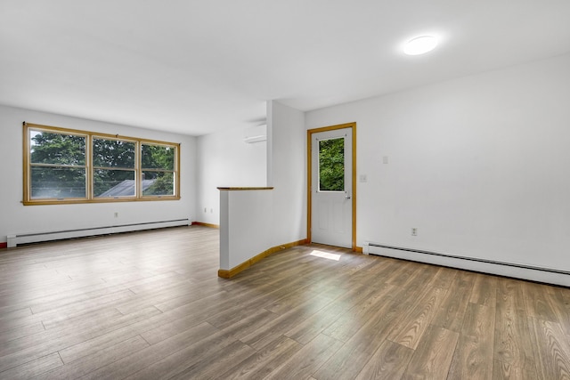 32 Thorne Ave, Lewiston, ME 04240 - unfurnished room with a baseboard radiator, wood finished floors, baseboards, and a wall unit AC