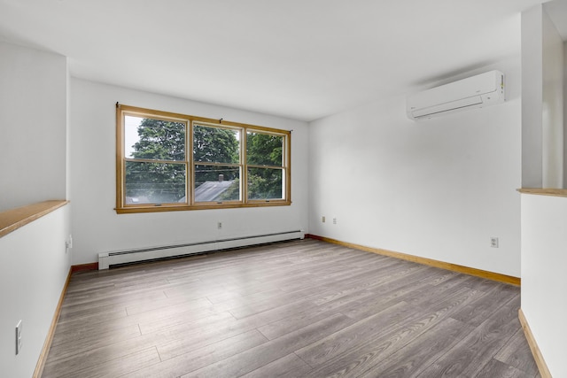 32 Thorne Ave, Lewiston, ME 04240 - unfurnished room featuring baseboard heating, a wall mounted air conditioner, wood finished floors, and baseboards