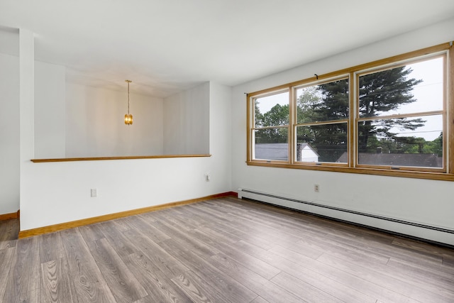 32 Thorne Ave, Lewiston, ME 04240 - empty room featuring baseboard heating, wood finished floors, baseboards, and a chandelier