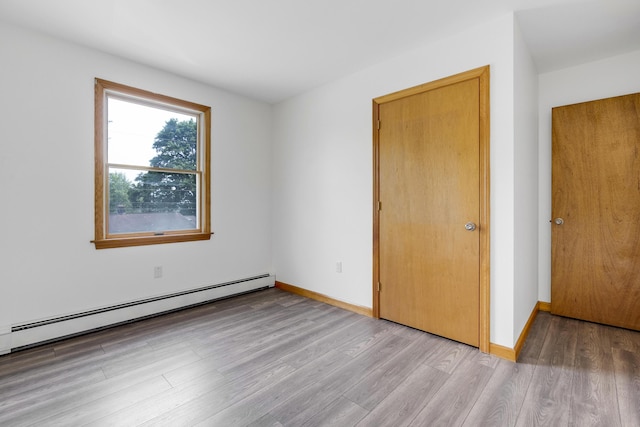 32 Thorne Ave, Lewiston, ME 04240 - unfurnished bedroom featuring a baseboard radiator, light wood-style floors, and baseboards