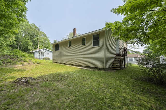 32 Thorne Ave, Lewiston, ME 04240 - back of property with a chimney, a yard, and stairs