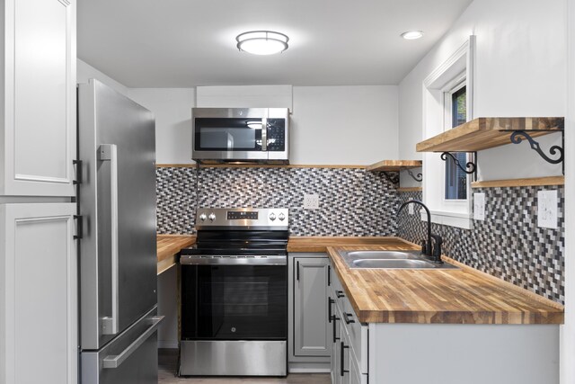 441 Middle Rd, Woolwich, ME 04579 - kitchen with open shelves, butcher block countertops, appliances with stainless steel finishes, a sink, and backsplash
