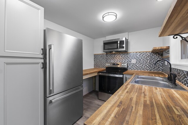 441 Middle Rd, Woolwich, ME 04579 - kitchen featuring wood counters, stainless steel appliances, a sink, open shelves, and tasteful backsplash