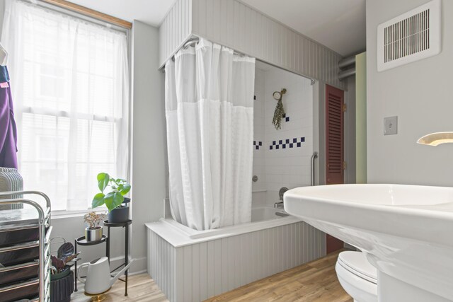 66 Spruce St Unit 1, Portland, ME 04102 - full bathroom featuring healthy amount of natural light, wood finished floors, toilet, and shower / bath combination with curtain
