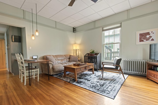 66 Spruce St Unit 1, Portland, ME 04102 - living room with radiator heating unit, wood finished floors, a ceiling fan, and a drop ceiling