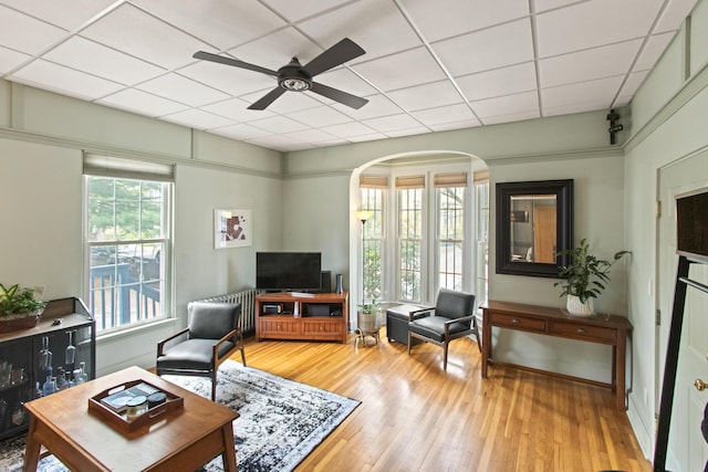 66 Spruce St Unit 1, Portland, ME 04102 - living area featuring arched walkways, light wood-style floors, ceiling fan, and a paneled ceiling