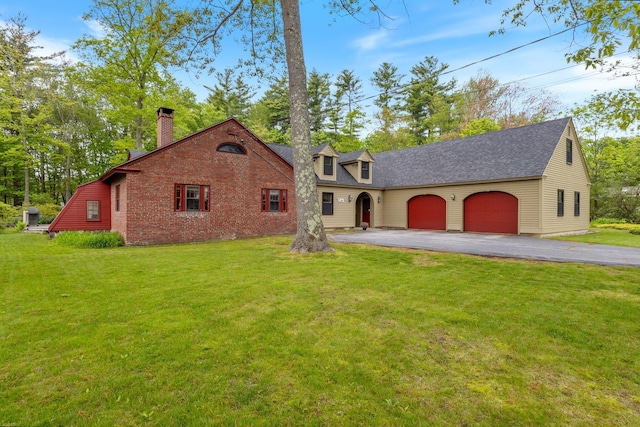18 Laurel Ln, Eliot, ME 03903 - view of front of property featuring driveway, a garage, a front lawn, a chimney, and a shingled roof