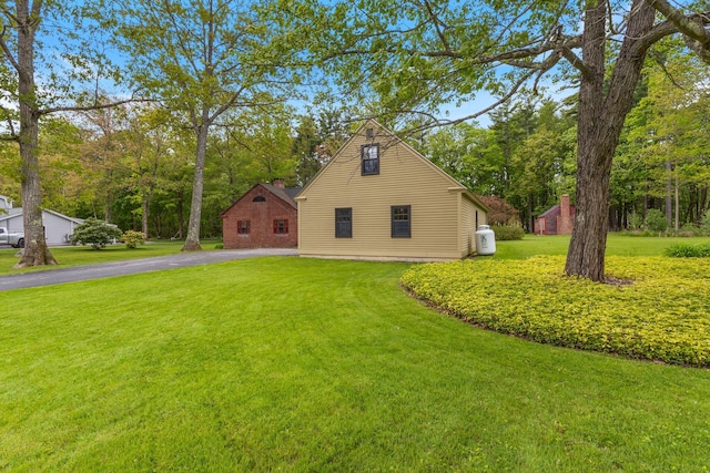 18 Laurel Ln, Eliot, ME 03903 - view of side of property featuring a lawn, asphalt driveway, and a chimney
