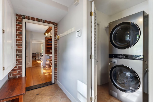 18 Laurel Ln, Eliot, ME 03903 - laundry room with stacked washing machine and dryer, light tile patterned floors, and brick wall