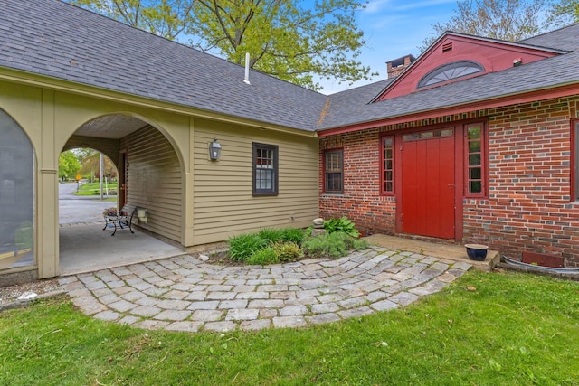 18 Laurel Ln, Eliot, ME 03903 - property entrance with brick siding, a patio, a chimney, and roof with shingles