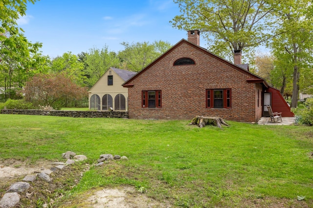 18 Laurel Ln, Eliot, ME 03903 - rear view of house featuring a chimney, a lawn, a patio, and brick siding